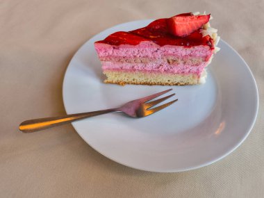 Beyaz bir tabakta nefis bir çilekli pasta dilimlemek, Nisan ayı fotokopi uzayı boyunca rahat bir Prag Kafe 'nin tadını çıkarmak.