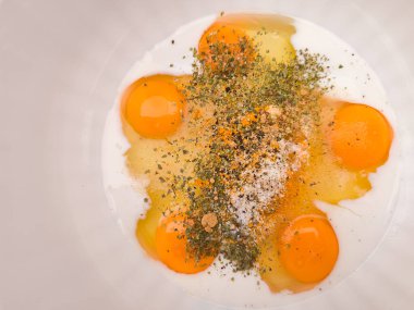 Dört kırık yumurta, süt ve baharat bir kâsede harmanlanır ve fotokopi alanı pişirmeye hazır canlı bir karışım yaratır.