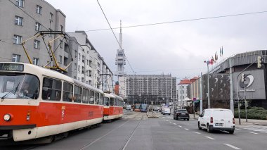 Prag, Çek Cumhuriyeti - 24 Mart 2025: Taboritska caddesinden geçen kırmızı ve beyaz tramvay, Olsanka otelinden geçiyor ve arka planda Zizkov televizyon kulesi, Prag, Çzech cumhuriyeti
