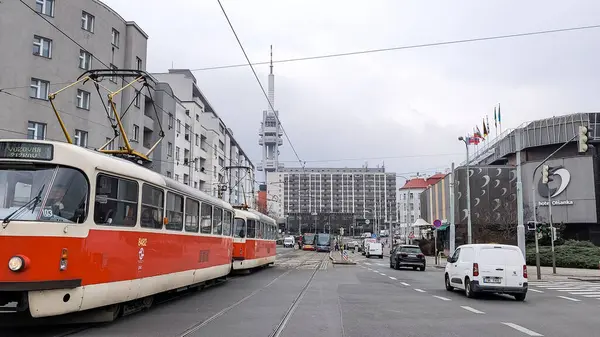 Prag, Çek Cumhuriyeti - 24 Mart 2025: Taboritska caddesinden geçen kırmızı ve beyaz tramvay, Olsanka otelinden geçiyor ve arka planda Zizkov televizyon kulesi, Prag, Çzech cumhuriyeti