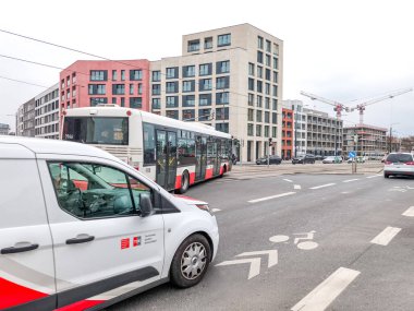 Prag, Çek Cumhuriyeti - 24 Mart 2025: Tramvay, Zizkov Prag 'ın 3 czechia ilçesinde yeni binalar ve inşaat vinçleriyle kavşakta beklerken, beyaz teslimat aracı kavşakta bekliyor