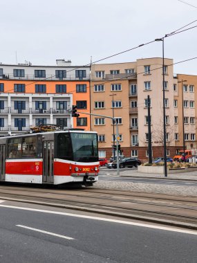 Prag, Çek Cumhuriyeti - 24 Mart 2025: Zizkov İlçesi Prag 3, Czechia 'da Malesicka caddesinde kırmızı ve beyaz tramvay, renkli konut binalarının yanından geçiyor