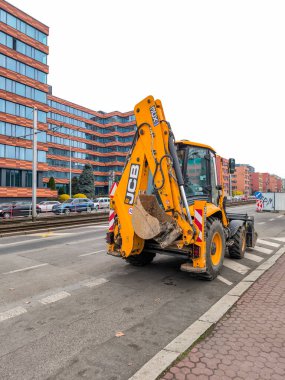 Prag, Çek Cumhuriyeti - 24 Mart 2025: Sarı jcb kepçe yükleyicisi, Prag 'ın Zizkov ilçesi Prag 3, Czechia' da Pitterova caddesindeki bir inşaat sahasına yakın park etti.
