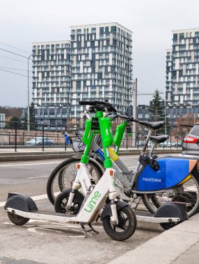 Prag, Çek Cumhuriyeti - 24 Mart 2025: Elektrikli scooterlar ve Prag 'ın Zizkov ilçesi Prag 3' te kullanıma hazır bir bisiklet paylaşım istasyonu, sürdürülebilir kentsel ulaşım imkanı sunuyor