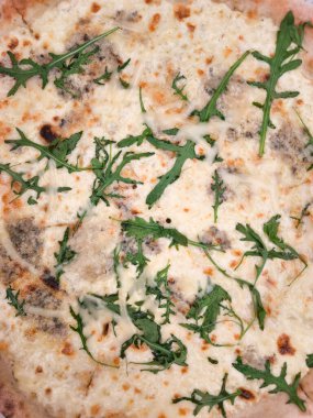 Mozzarella, gorgonzola, provolone ve parmesan peynirli dört peynirli pizzanın üstüne roka kopyalama alanı.