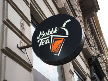 Prag, Çek Cumhuriyeti - 15 Nisan 2025: Bir binanın ön cephesinden sarkan yuvarlak siyah baloncuklu çay tabelası, kentsel manzaraya şık bir dokunuş ekleyerek moda bir içeceği tanıtıyor