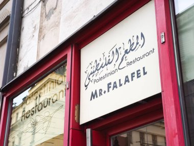 Prag, Çek Cumhuriyeti - 15 Nisan 2025: Bay Falafel adında iki dilli bir Filistin restoranının işareti, Arapça ve İngilizce kelimelerin yer aldığı, Orta Doğu mutfağını destekleyen