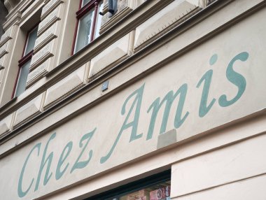 Prag, Çek Cumhuriyeti - 15 Nisan 2025: Prag, Çek Cumhuriyeti 'ndeki bir binada açık kahverengi bir duvar süsleyen yeşil Chez amis, yerel cazibe ve konukseverlik besin deposunu vurguluyor