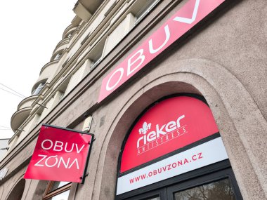 Prag, Çek Cumhuriyeti - 15 Nisan 2025: Czech cumhuriyetindeki bir binayı süsleyen, kentsel perakende cazibesini ön plana çıkaran Obuv zona ve Rieker antistresi için kırmızı ve beyaz mağaza tabelaları