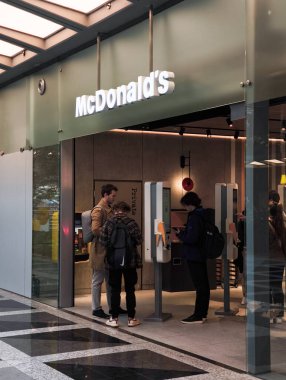 Prag, Çek Cumhuriyeti - 15 Nisan 2025: Bir McDonalds restoranında dijital büfe kullanan müşteriler, modern fast food siparişlerinin altını çiziyor