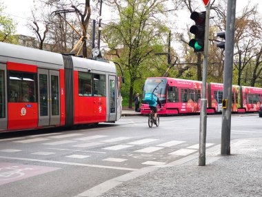 Prag, Çek Cumhuriyeti - 15 Nisan 2025: Prag 'da yoldan geçen tramvaylı Wolt Bisiklet kuryesi, kentsel hareketlilik ve dağıtım hizmetleri sergiliyor