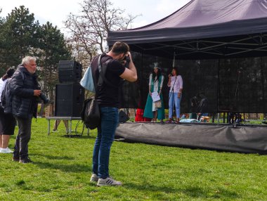 Prag, Çek Cumhuriyeti - 12 Nisan 2025: Prag 'da bir sahnede geleneksel giysili Kazak kadınların fotoğraflarını çeken fotoğrafçılar