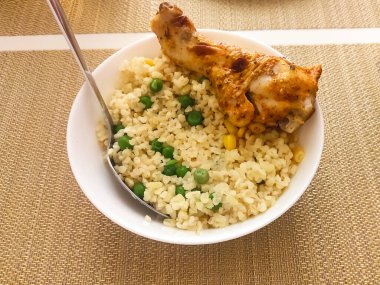 Yumuşak taneciklerle dolu ılık bir kase, tepesinde dinlenen yumuşak bir tavuk parçası, canlı yeşil bezelyeler ve tatlı mısırlar, havada süzülen aromalar, tatmin edici bir öğle yemeği ya da akşam yemeği için mükemmel.