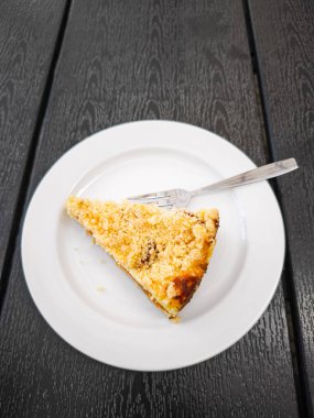 Bir çatal eşliğinde, beyaz bir tabakta sunulan kıtır kıtır kayısılı kek dilimi, tatlı sevenleri her kutlama ya da fırsat için mükemmel bir ziyafete davet ediyor. Boşluğu kopyala