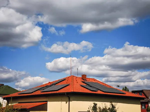 Güneş panelleri, çarpan bir gökyüzünün altında, yenilenebilir enerji ve sürdürülebilir yaşamın önemini vurgulayan çağdaş bir çatıya kurulmuştur.