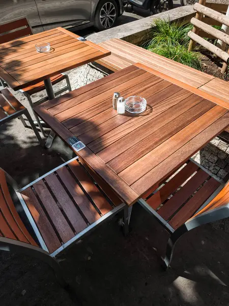 QR kodlu ahşap masalar ve güneş ışığıyla yıkanmış sandalyeler Prag, Czechia 'daki bir kafenin önündeki kaldırım taşları boş duruyor. Müşterilerin gelmesini bekliyorlar.