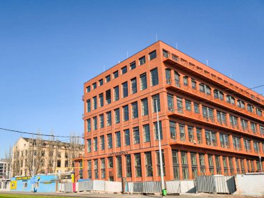 Prag, Çek Cumhuriyeti - 3 Nisan 2025: Prag, Czechia 'da turuncu cepheli çağdaş ofis binası, kentsel kalkınmayı ve yüksek Kolbenova' yı yeniden canlandırmayı simgeleyen mavi gökyüzüne karşı dimdik ayakta duruyor