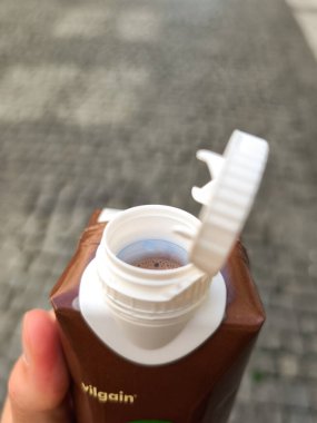 Prag, Çek Cumhuriyeti - 30 Nisan 2025: Prag, Czechia 'da bulanık bir sokak geçmişine açık kapaklı kısmen açılmış bir kutu çikolatalı protein içeceği köşkü