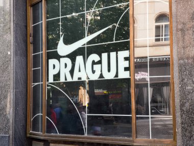 Prag, Çek Cumhuriyeti - 30 Nisan 2025: Prag, Czech cumhuriyetindeki cam bir pencerede büyük bir logo ve Prag işareti sergilendi, kentsel çevreyi yansıtıyor