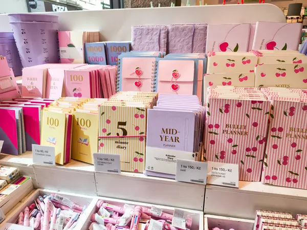 Prag, Çek Cumhuriyeti - 30 Nisan 2025: Pastel renkli defterler, günlükler ve planlamacıların vişne motifleri bir kırtasiye dükkanında raflarda sergilenen Uçan Kaplan Vibrant gösterisi