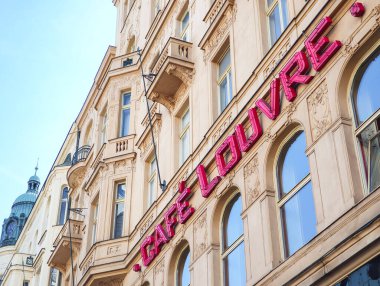 Prag, Çek Cumhuriyeti - 30 Nisan 2025: Prag, Czechia 'da Avrupa mimarisi ve kafe kültürünün sergilendiği tarihi bir bina, ünlü cafe louvre' nin pembe neon işareti