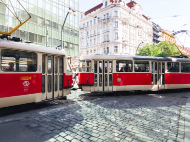 Prag, Çek Cumhuriyeti - 30 Nisan 2025: Prag, Czechia 'da güneşli bir günde iki tramvay kentin toplu taşıma sisteminin sergilendiği bir kavşakta buluşuyor