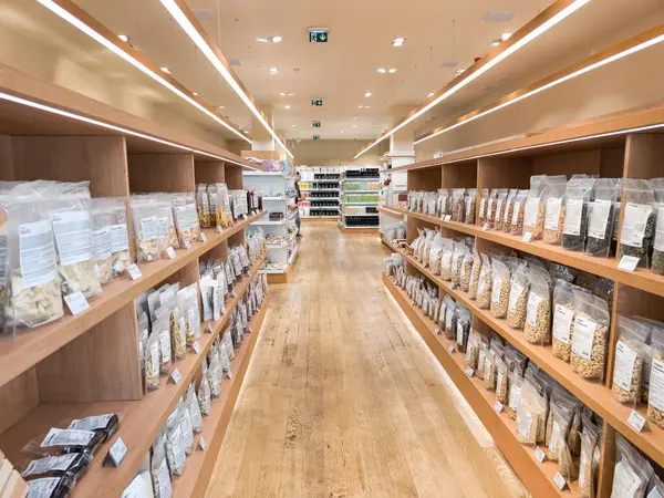 Prag, Çek Cumhuriyeti - 30 Nisan 2025: Vilgain Tahta rafları çeşitli paketlenmiş gıda ürünleriyle dolu, Prag, Czechia 'daki modern bir markette davetkar bir atmosfer yaratıyor