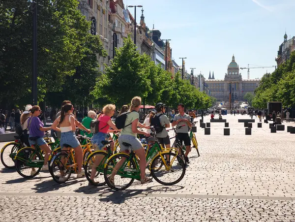 Prag, Çek Cumhuriyeti - 30 Nisan 2025: Wenceslas Meydanı 'nda bisiklet süren turistler, Prag, Czechia' da güzel bir günde güneşin tadını çıkarıyorlar.