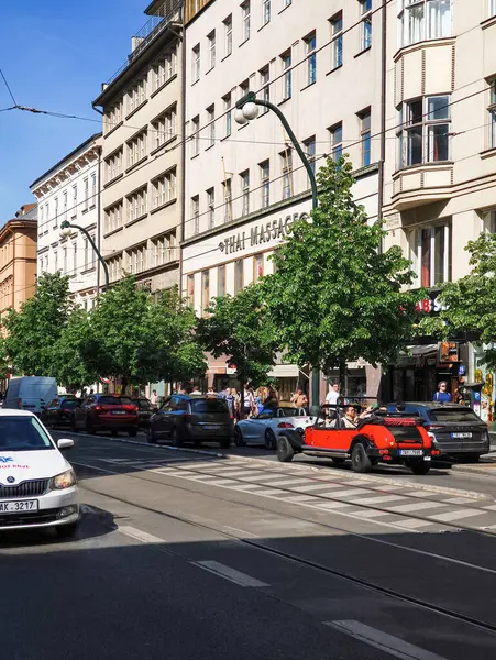 Prag, Çek Cumhuriyeti - 30 Nisan 2025: Turistler, güneşli bir günde geleneksel binalar ve Thai masaj salonlarının yanında Narodni caddesindeki klasik arabalarla gezinin tadını çıkarıyorlar