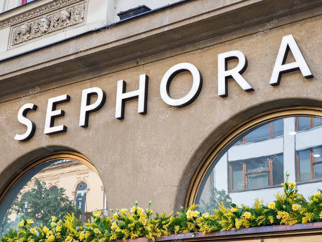 Prague, Czech republic - April 30, 2025: Large illuminated sephora sign on a building facade with yellow flowers, located in prague, czechia