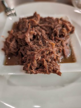 Lokanta masasında pişmiş sığır eti küçük, kare bir kaseye doluyor, eğlenmeye hazır.