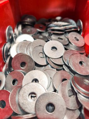 Kırmızı bir konteynırı dolduran sayısız metal temizleyiciyi kapatın, inşaat ve diy projeleri için gerekli donanım sergileniyor