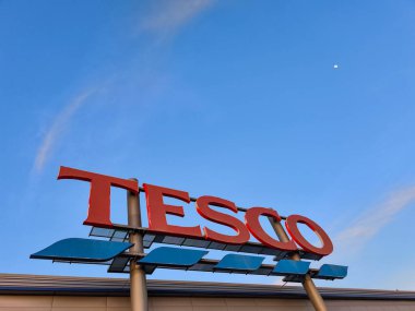 Prag, Çek Cumhuriyeti - 6 Mayıs 2025: Tesco logosu açık mavi gökyüzüne karşı aydınlatıldı