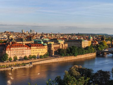 Prag, Çek Cumhuriyeti - 6 Mayıs 2025: Vltava Nehri Prag 'ın kalbinde zarif bir şekilde akıyor, Letna Park' tan batan güneşin yüzeyindeki ılık renkleri yansıtıyor.