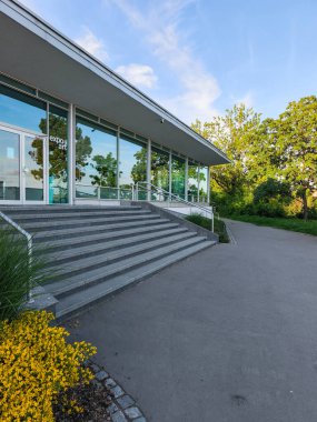 Prag, Çek Cumhuriyeti - 6 Mayıs 2025: Güneşli bir günde, Letna Parkı, Prag, Czechia 'da merdivenleri, sarı çiçekleri ve ağaçları olan modern sanat galerisi