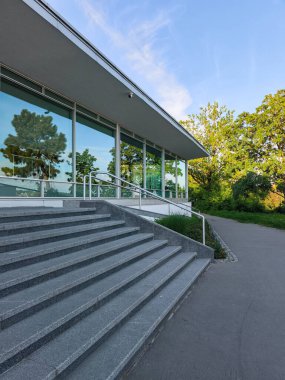 Prag, Çek Cumhuriyeti - 6 Mayıs 2025: Ağaçları yansıtan cam cepheli modern bina, Letna Parkı, Prag, Czechia 'da yer alıyor.