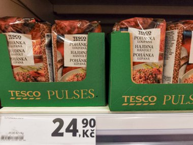 Prag, Çek Cumhuriyeti - 6 Mayıs 2025: Karabuğday paketleri bir tesco süpermarketinde rafta sergileniyor, ürün detayları ve Czech koruna 'da fiyat gösteriliyor