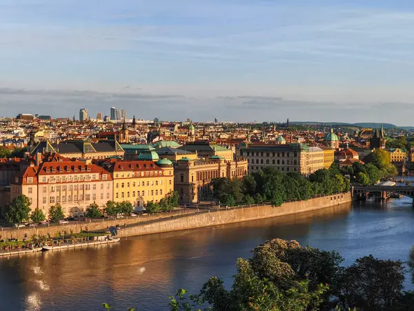 Prag, Çek Cumhuriyeti - 6 Mayıs 2025: Vltava Nehri Prag 'ın kalbinde zarif bir şekilde akıyor, Letna Park' tan batan güneşin yüzeyindeki ılık renkleri yansıtıyor.