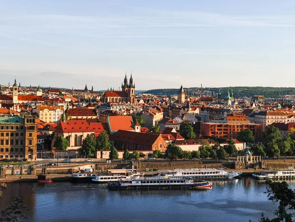 Prag, Çek Cumhuriyeti - 6 Mayıs 2025: Vltava nehri, turizm tekneleri, tarihi binalar ve Letna Park 'tan güneşli bir gökyüzü altında Prag kiliselerinin panoramik manzarası
