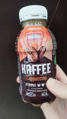 Prag, Çek Cumhuriyeti - 13 Eylül 2024: Müller Kafe 'nin güçlü kapuçinosunu tutan ve ürünün ambalajını ve markasını gösteren bir ele yaklaşın