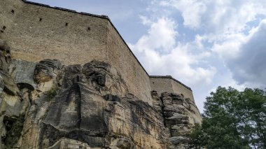 Konigstein, Saksonya, Almanya - 24 Ağustos 2019: Konigstein Kalesi 'nin duvarları kumtaşı uçurumlarından yükseliyor. Saksonya, Almanya' da tarihi bir dönüm noktası.