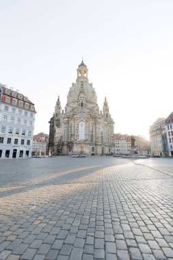 Dresden, Almanya - 7 Eylül 2024: sabahın erken saatlerinde görkemli bir şekilde yükseliyor. Dresden 'deki Frauenkirche' in kaldırım taşı meydanında uzun gölgeleri var. Seyahat konsepti. Yüksek kalite fotoğraf