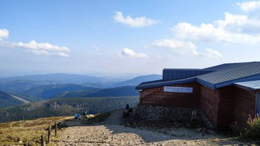 Pec pod Snezkou, Çek Cumhuriyeti - 31 Ağustos 2019: Sığınak yakınlarındaki bir dağ yolunda yürüyen yürüyüşçüler, Ağustos 'ta Çek Cumhuriyeti' ndeki krkonose dağ sırasının panoramik manzarasının keyfini çıkarıyorlar