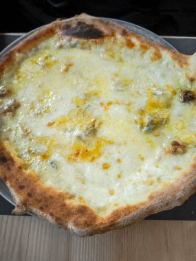 Taze pişmiş peynirli pizzaya yakın, çıtır çıtır, altın rengi kahverengi kabuklu, eritilmiş peynir ve zengin tatlar sergileniyor, Aosta, İtalya 'da yakalandı.