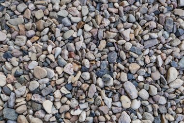 Küçük, çok renkli çakıl taşlarının arka planı desenli, doğal bir yüzey yaratıyor. Vysocany bölgesi Prag 9