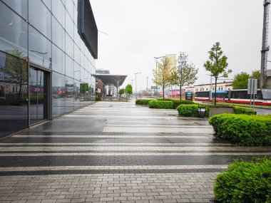 Prag, Çek Cumhuriyeti - 25 Nisan 2025: Alışveriş merkezi Harfa dış görünümü, modern kent mimarisini ön plana çıkaran ıslak kaldırımlar ve yeşil çalılıklar içeriyor