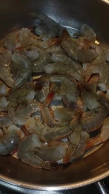 Taze karidesler bir tavada pişiyor ve İtalya 'nın bibibione kentinin yaz aylarında aşçılık sahnesine bir göz atıyorlar. Yüksek kaliteli FullHD görüntüler