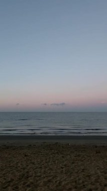 Yumuşak pastel renkler bir kumsalın üstündeki gökyüzünü boyar ve yumuşak dalgalar İtalya 'nın güneşin doğuşuyla kıyıya vurur. Yüksek kaliteli FullHD görüntüler