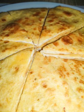 Erimiş peynirle dolu cızırdayan quesadilla tabakta sunulur, mükemmel üçgenler halinde dilimlenir, cazip bir altın kabuk gösterilir ve nefis bir mutfak deneyimi sunulur.