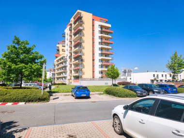 Prag, Çek Cumhuriyeti - 1 Mayıs 2025: Güneşli bir günde rahat bir şehir yaşamı sunan balkonlu ve otoparklı modern apartman